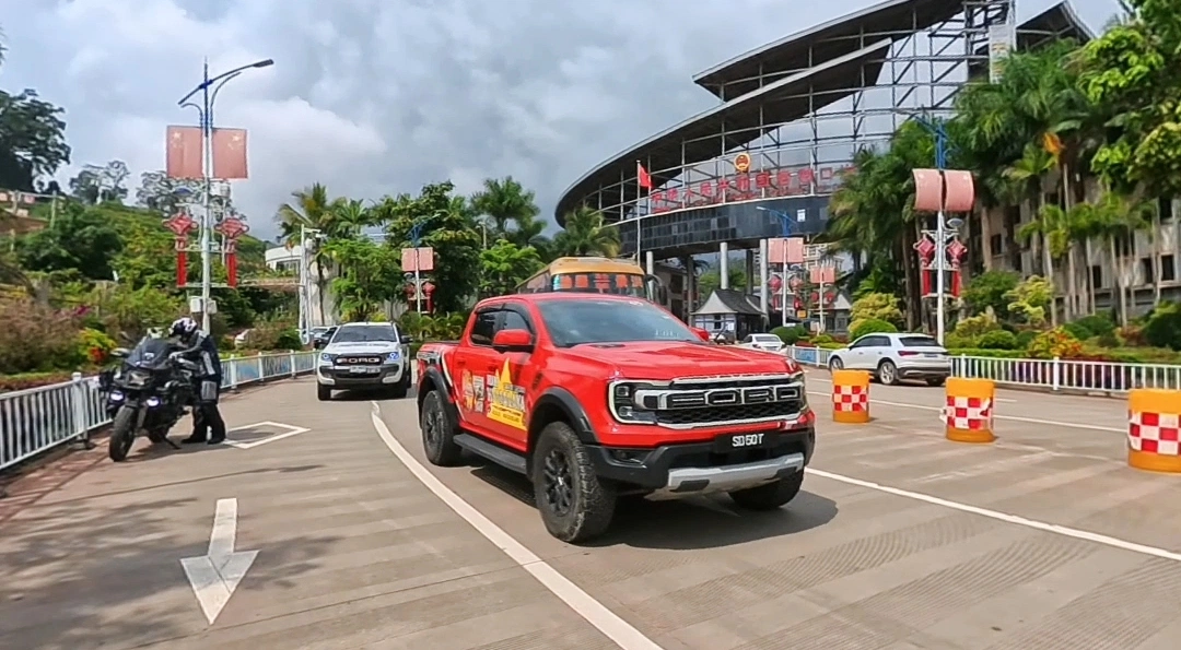 Red Ford F-150 pickup truck driving at a China border port